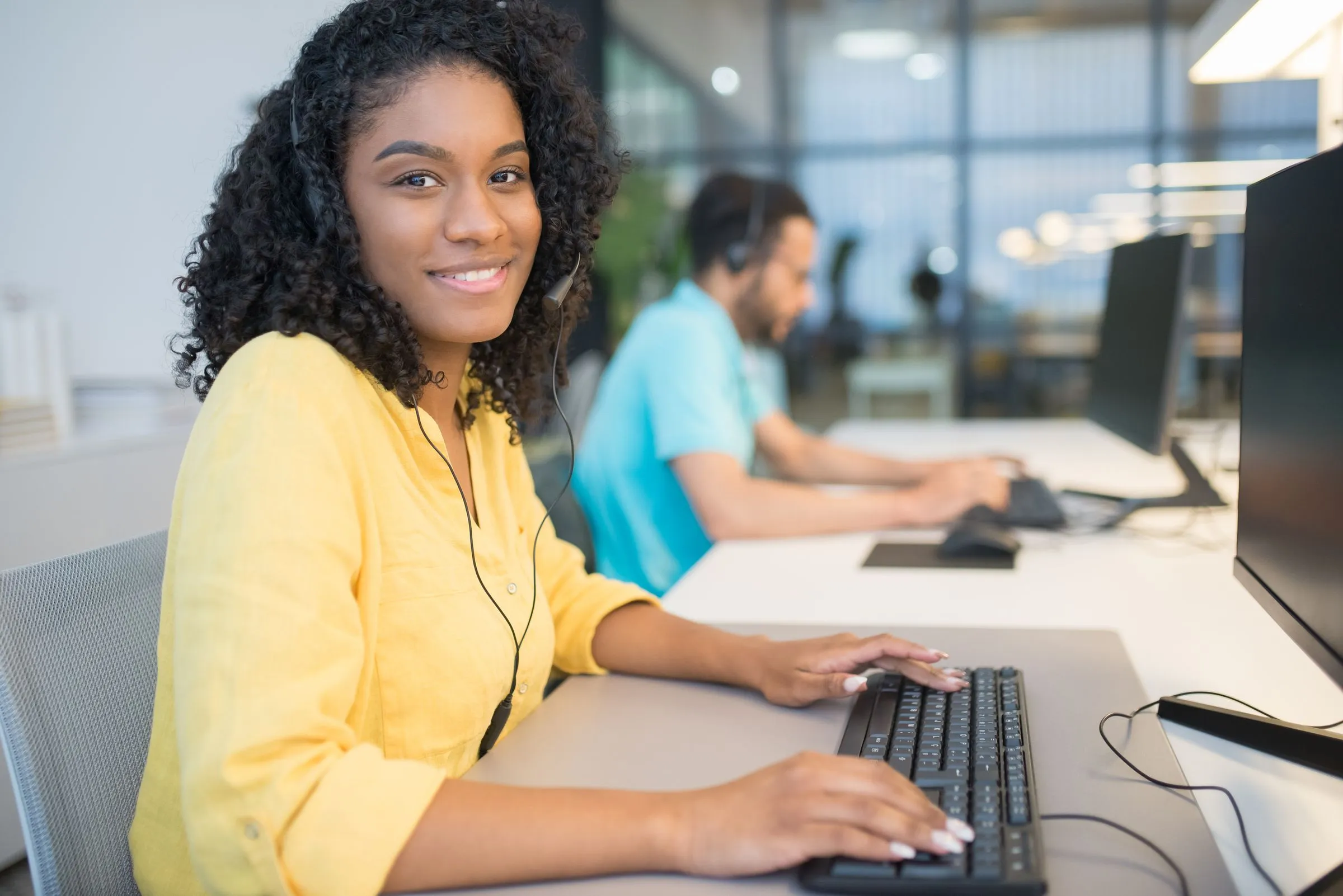 A support specialist with a headset working at her desk