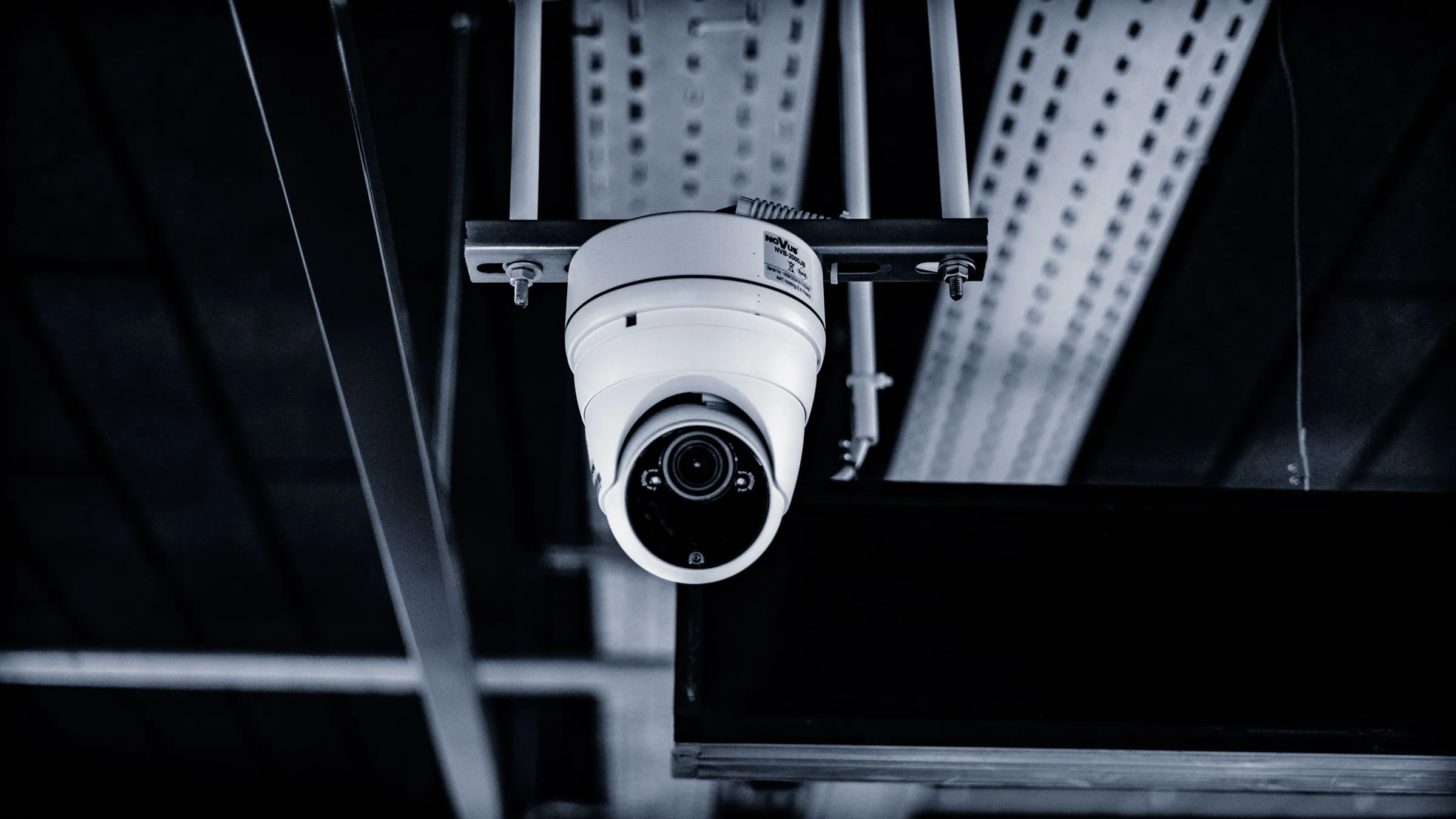 A white dome security camera mounted on a ceiling